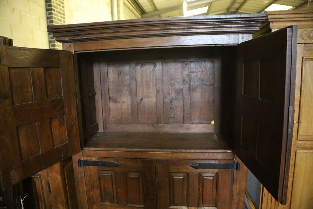 A French oak rustic-style panelled cupboard fitted upper and lower pairs of doors, width 122cm, depth 50cm, height 198cm